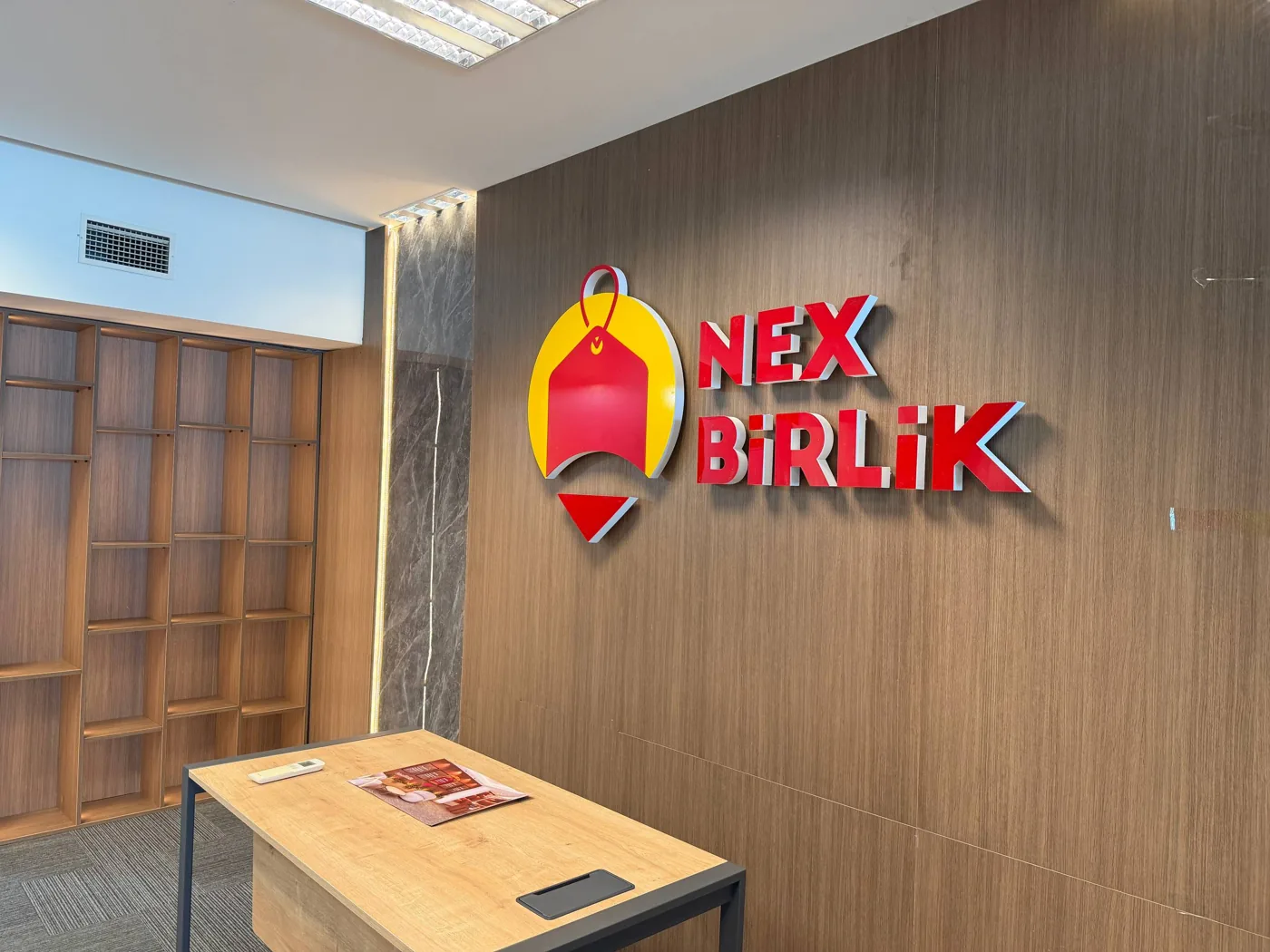 Ahşap duvarda marka işareti ve önünde masa