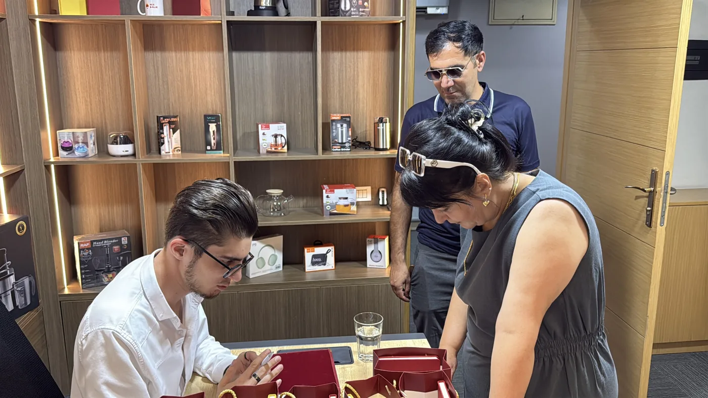 Kırmızı çantaların bulunduğu masa etrafında sohbet · müşterinin sağladığı fotoğraf